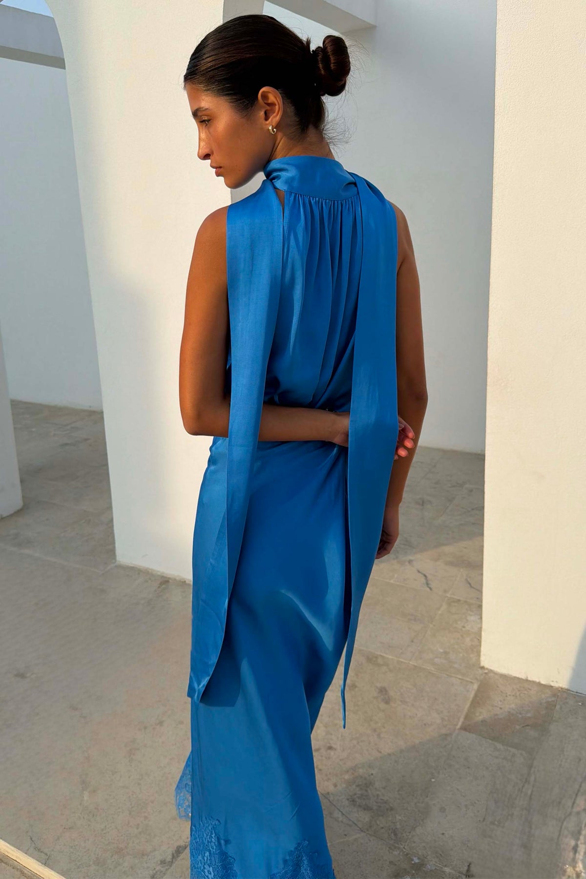 Modella alta 162 cm (taglia 6 UK) con il Top Cobalt Lily blu cobalto in raso e drappeggio posteriore.