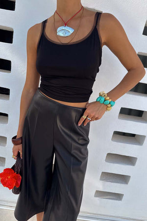 Black Vegan Leather Culottes featuring a wide leg and front crease, styled with turquoise accessories.