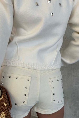 Ecru Studded Hot Pant with silver details on back pockets, paired with a matching cream top.