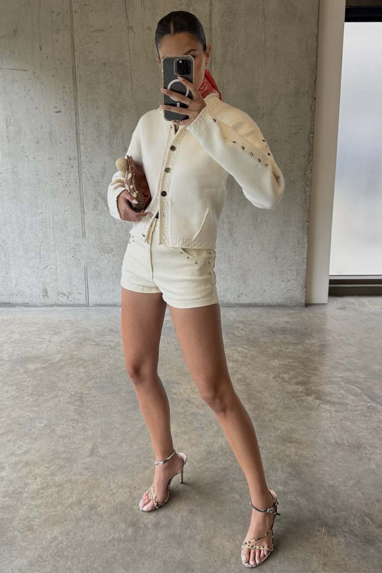 Ecru Studded Hot Pant in cream cotton with silver studs, paired with a matching jacket and heels.
