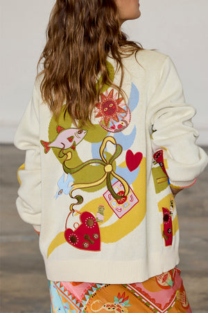 Cream Multi Enchanted Cardigan featuring colourful sun, heart and fish motifs on the back of a soft knit.