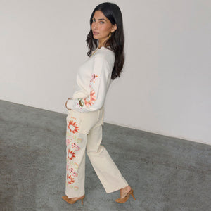 Jeans Ecru Enchanted a gamba ampia con ricami a sole e bordi a festone, abbinati a un cardigan coordinato.