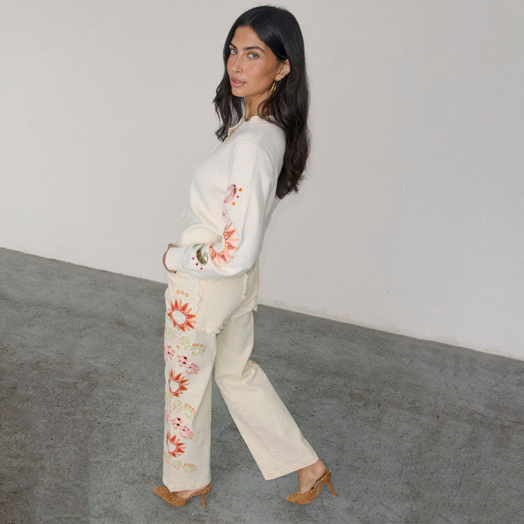 Jeans Ecru Enchanted a gamba ampia con ricami a sole e bordi a festone, abbinati a un cardigan coordinato.