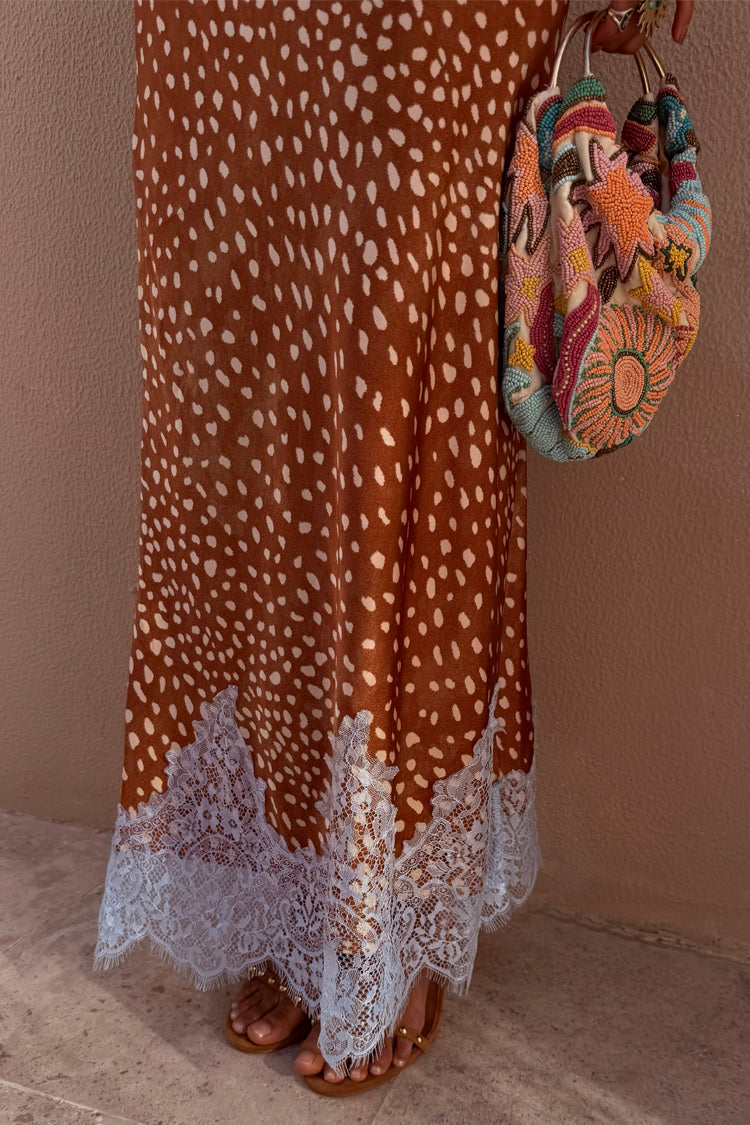 Gonna midi Maeva con stampa fawn e bordo in pizzo bianco, indossata con borsa decorata con perline.