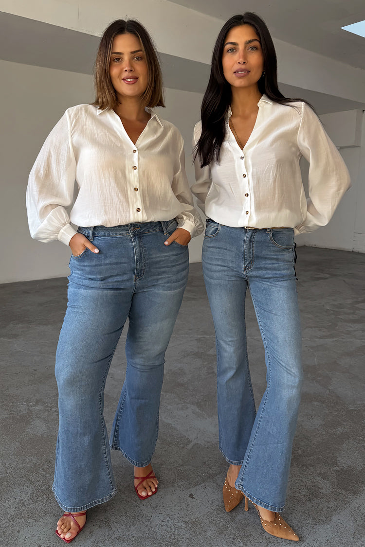Jeans Flare Scallop in denim blu anni '70, indossati da due modelle per mostrare le taglie inclusive.