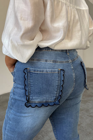 Jeans svasati Blue Denim Flare con tasche posteriori smerlate blu navy, indossati da una modella taglia 18.