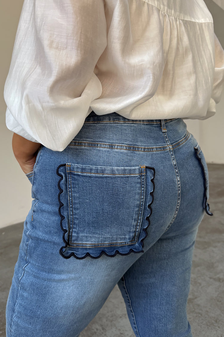 Jeans svasati Blue Denim Flare con tasche posteriori smerlate blu navy, indossati da una modella taglia 18.