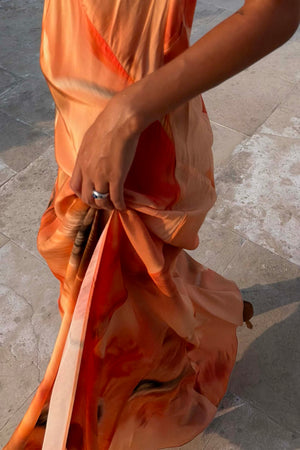Burnt orange Blurred Floral Sofia Dress highlighting the fluid bias-cut drape and side slit.