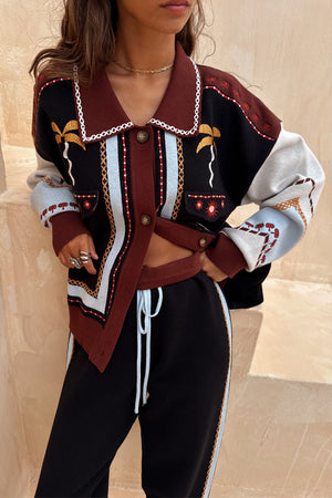 Geometric Knit Cardigan featuring palm motifs, blanket stitch trim and a structured collar in autumnal tones.