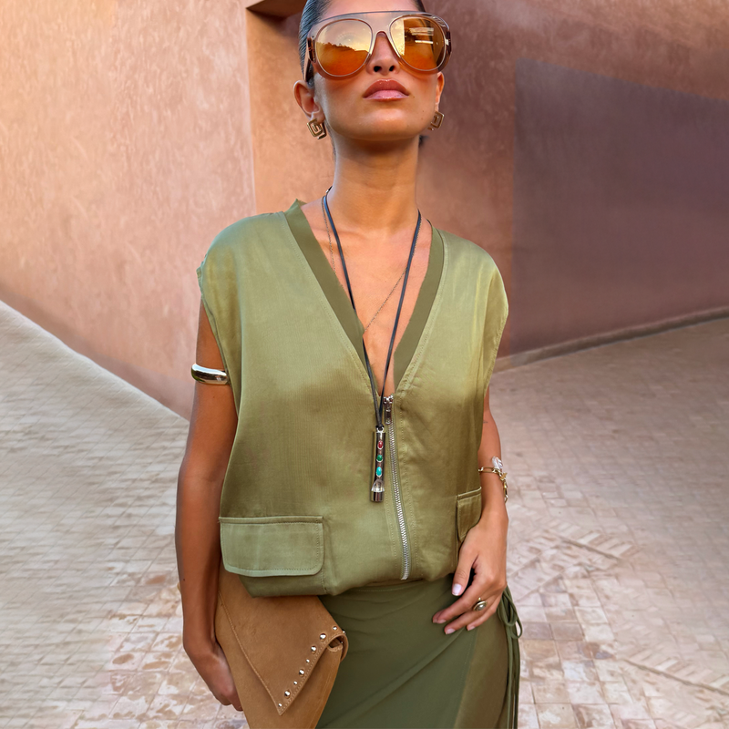 Olive Bubble Zip Vest in khaki green with a zip front, utility patch pockets and drawcord hem, styled for a vacation.