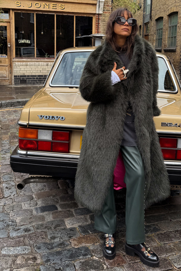 Green Faux Fur Coat featuring a relaxed silhouette and pink lining, styled against a vintage car.
