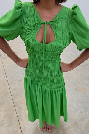 Green Shirred Nara Dress featuring a multi-wear tie neck, puff sleeves, and an elasticated smocked bodice.