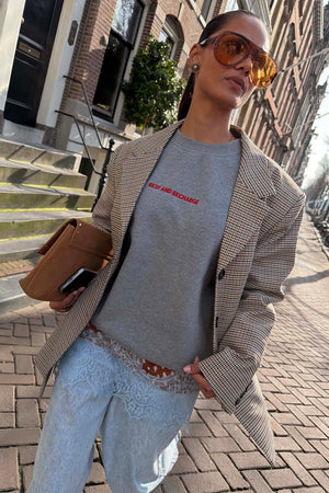 Check Blazer a quadri sopra una felpa grigia e jeans con pizzo in un look street style.