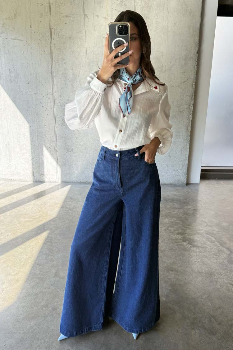 Blue Denim Pallazzo Jan Jean with a wide-leg fit, paired with a white shirt and a blue patterned neck scarf.