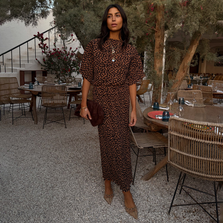 Lucia Leopard Tilly Dress Petite in an iconic leopard print plissé fabric, styled in an outdoor terrace setting.