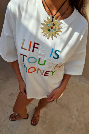 Relaxed white cotton T-shirt with colourful Life Is Tough Honey embroidered slogan.