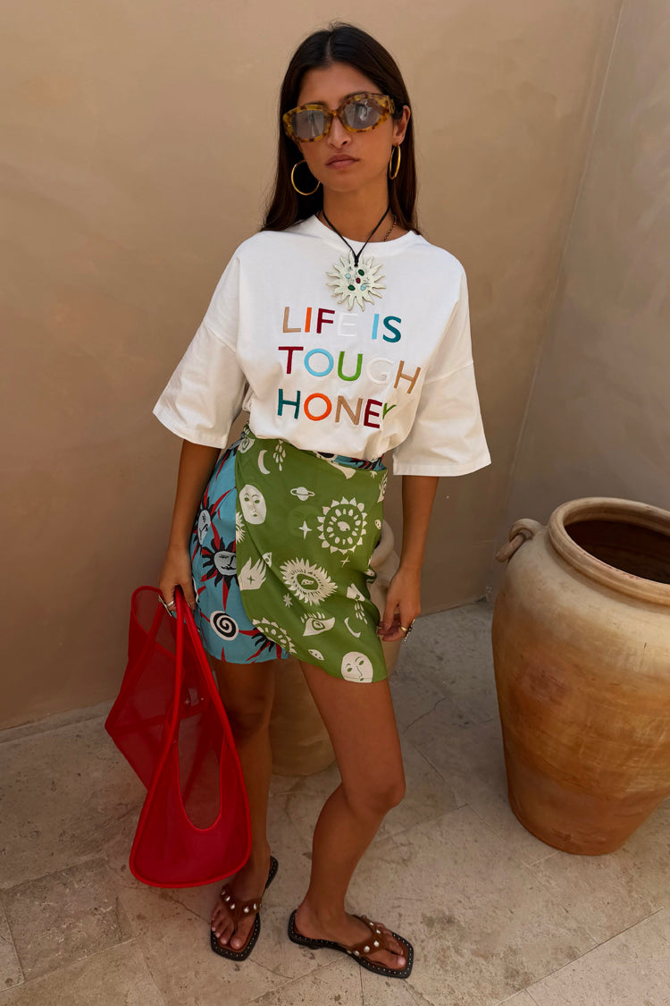 White Life Is Tough Embroidered T-Shirt with colourful slogan, styled with a celestial print wrap mini skirt.