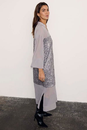 Gunmetal Sequin Lila Shirt Dress featuring silver sequins and sheer panels, styled with black pointed boots.