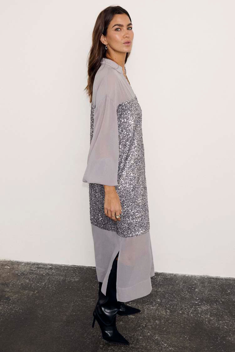 Gunmetal Sequin Lila Shirt Dress featuring silver sequins and sheer panels, styled with black pointed boots.