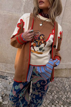 Cowgirl Martha Cardigan in tan with vintage western embroidery and red stitching, layered over a striped shirt.