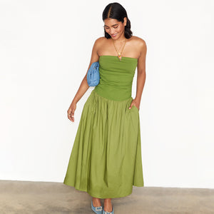 Olive Lola Mid-axi Dress featuring a ruched bandeau bodice and cotton skirt, styled with a blue clutch.
