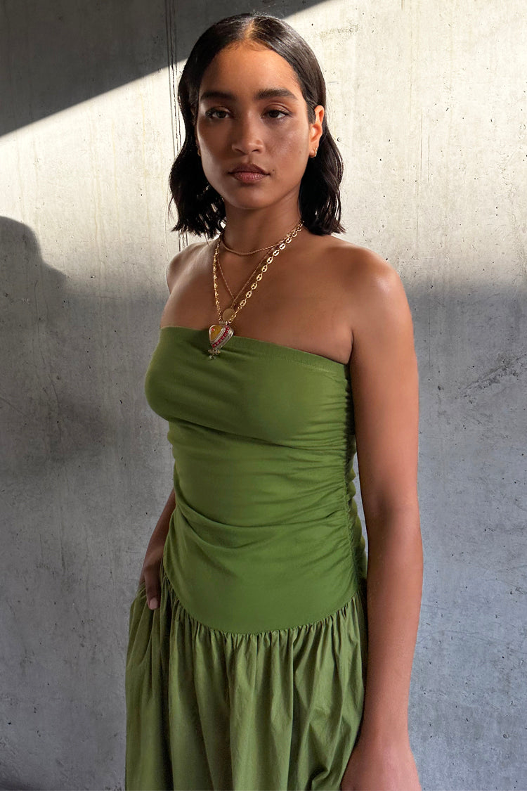 Olive Lola Mid-axi Dress with a strapless ruched bodice and gathered skirt, styled with layered gold necklaces.