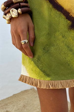 Green Ombre Deia Dress hem detail with a textured raffia trim and earthy green and yellow tones.