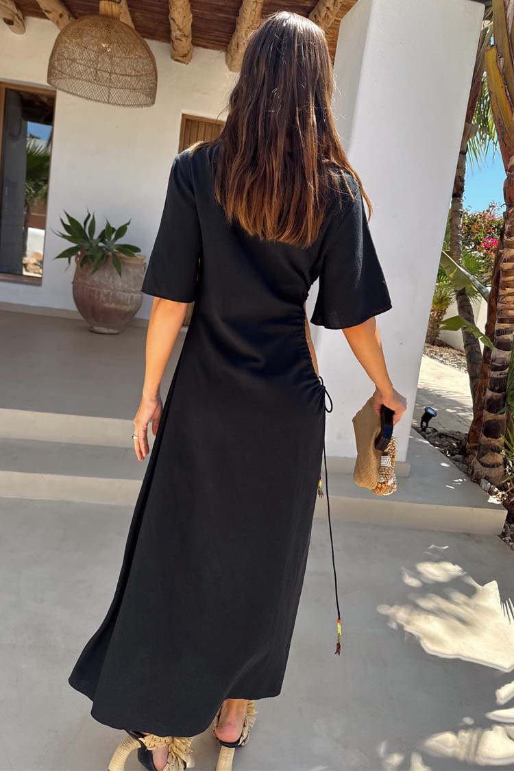 Black Palm Riviera maxi dress in a cotton blend with a waist cut-out and adjustable tie detail, shown from the back.