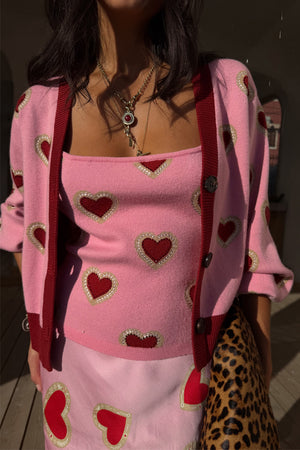 Canotta Pink Hearts in maglia rosa con cuori rossi e cardigan coordinato, abbinati a borsa leopardata.