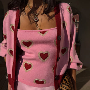 Top Pink Hearts in maglia rosa con motivi a cuore rossi e cardigan coordinato.