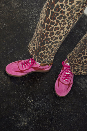 Pink and Red Leather Trainers in a sleek silhouette, paired with leopard print trousers for a street style London look.