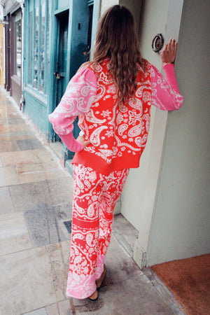 Cardigan Martha e pantaloni con stampa bandana rossa e rosa su una modella taglia M vista di spalle.