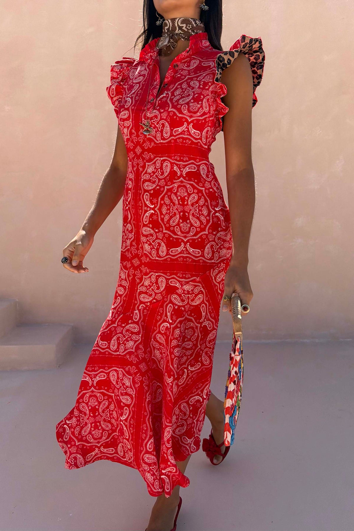 Red Bandana Remi Dress featuring leopard print ruffle sleeves and a frilled neckline in a sunny outdoor setting.
