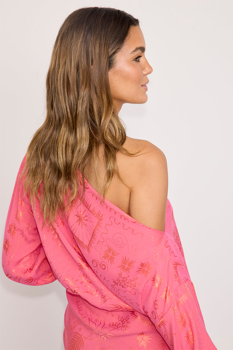Pink Safari Mini Tilly Dress in jacquard fabric with sun and palm prints, shown from a side-back profile.