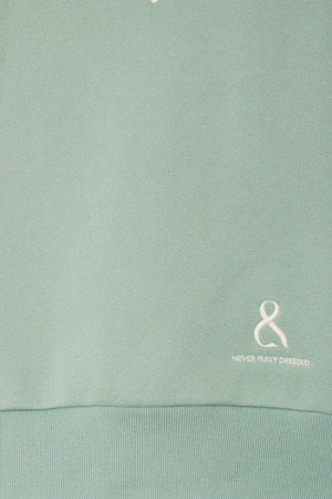Sage green Sage Sundazed Accessible Sweatshirt detail featuring an embroidered white logo and ribbed hem.
