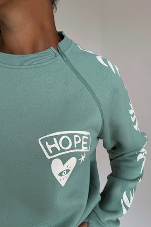 Sage Sundazed Accessible Sweatshirt in green with a cream HOPE graphic and concealed shoulder zip for treatment access.