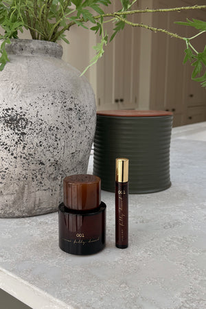 NFD Eau De Parfum 001 in full and travel sizes, designed in London with dark amber glass on a light stone surface.