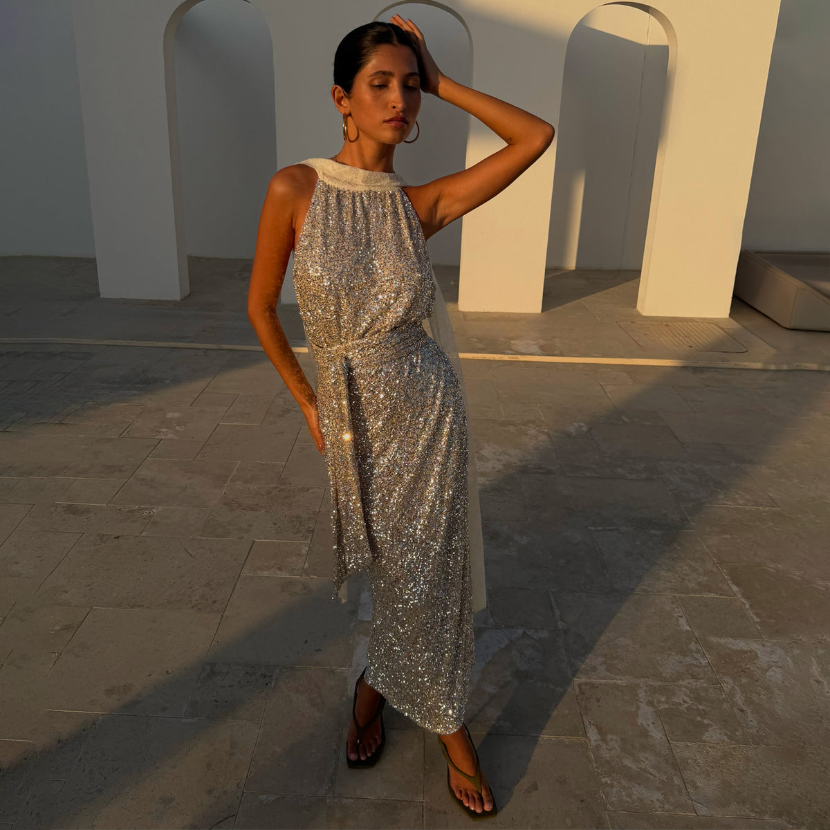 Gonna Jaspre maxi a portafoglio in paillettes argento con top coordinato all'aperto alla luce del tramonto.