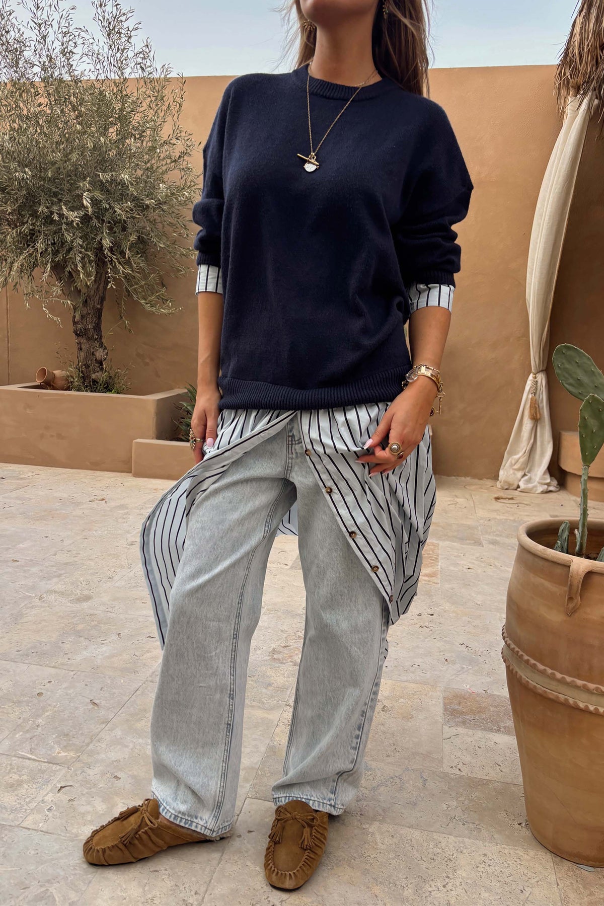 Navy knit jumper dress with a striped cotton skirt, styled over jeans for a multi-wear London look.