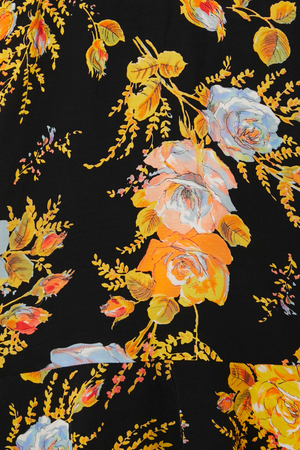 Black Sofia Mini Tea Dress detail highlighting the intricate orange and yellow floral print on a black base.