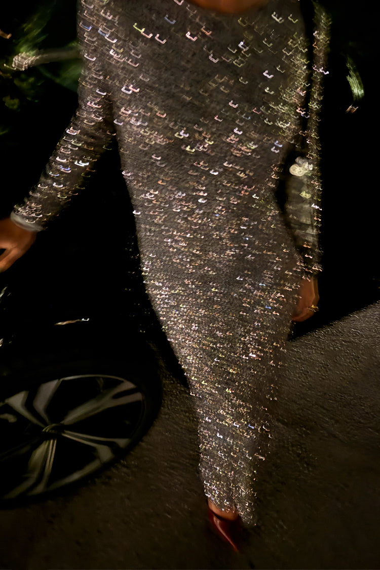 Gunmetal Sequin Soho Dress with long sleeves and a shimmering finish in a motion-blurred party setting.