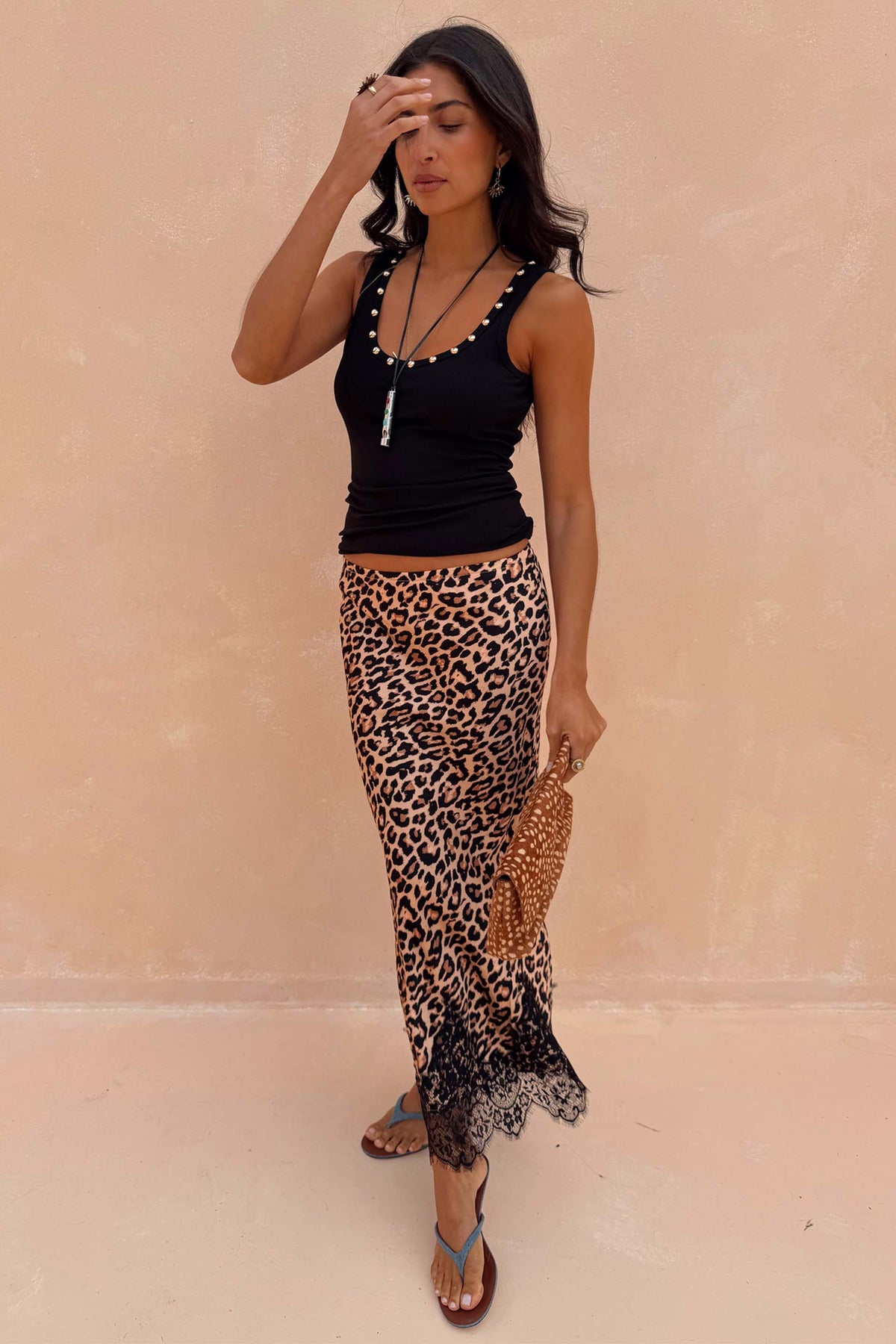 Black Studded Rib Vest featuring gold neckline detailing, styled with a leopard print lace-trimmed skirt.