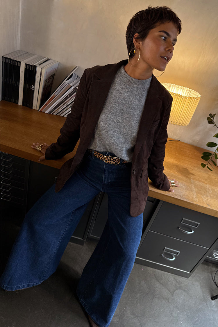 Premium Chocolate Suede Jacket in brown, layered with a grey knit and wide-leg denim for a transeasonal look.