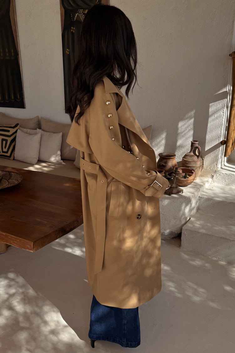Tan Trench Coat with gold studs on the sleeve and a waist belt, worn by a model who is 5ft7” and wears size M.