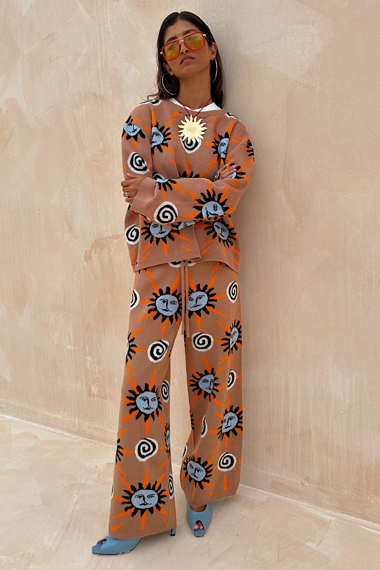 Modella con maglione Tan Sun Copenhagen e pantaloni coordinati marroni con stampa a soli.