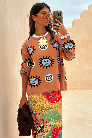 Maglione Tan Sun Copenhagen color cannella con stampe a sole, indossato da una modella per un selfie.