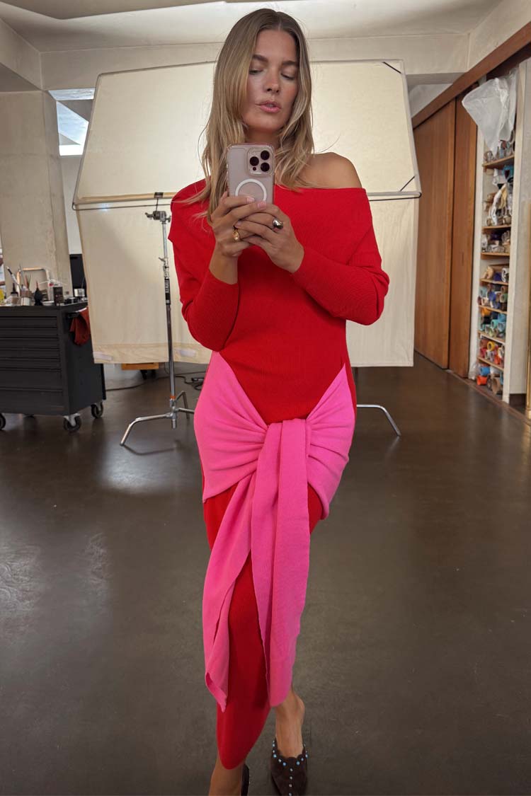 Red and pink Afia midi dress with a multi-wear wrap tie waist and off-the-shoulder style in a mirror selfie.
