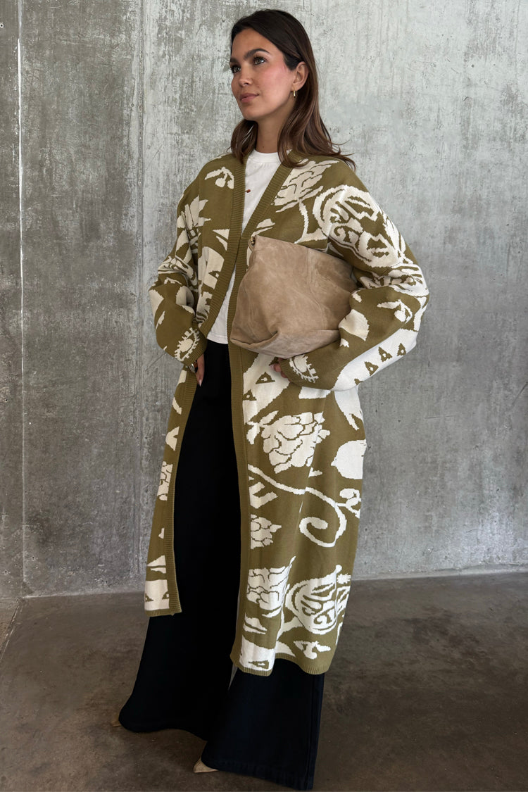 Olive Amara Knit Coatigan with cream hand-painted motifs, paired with black wide-leg trousers.