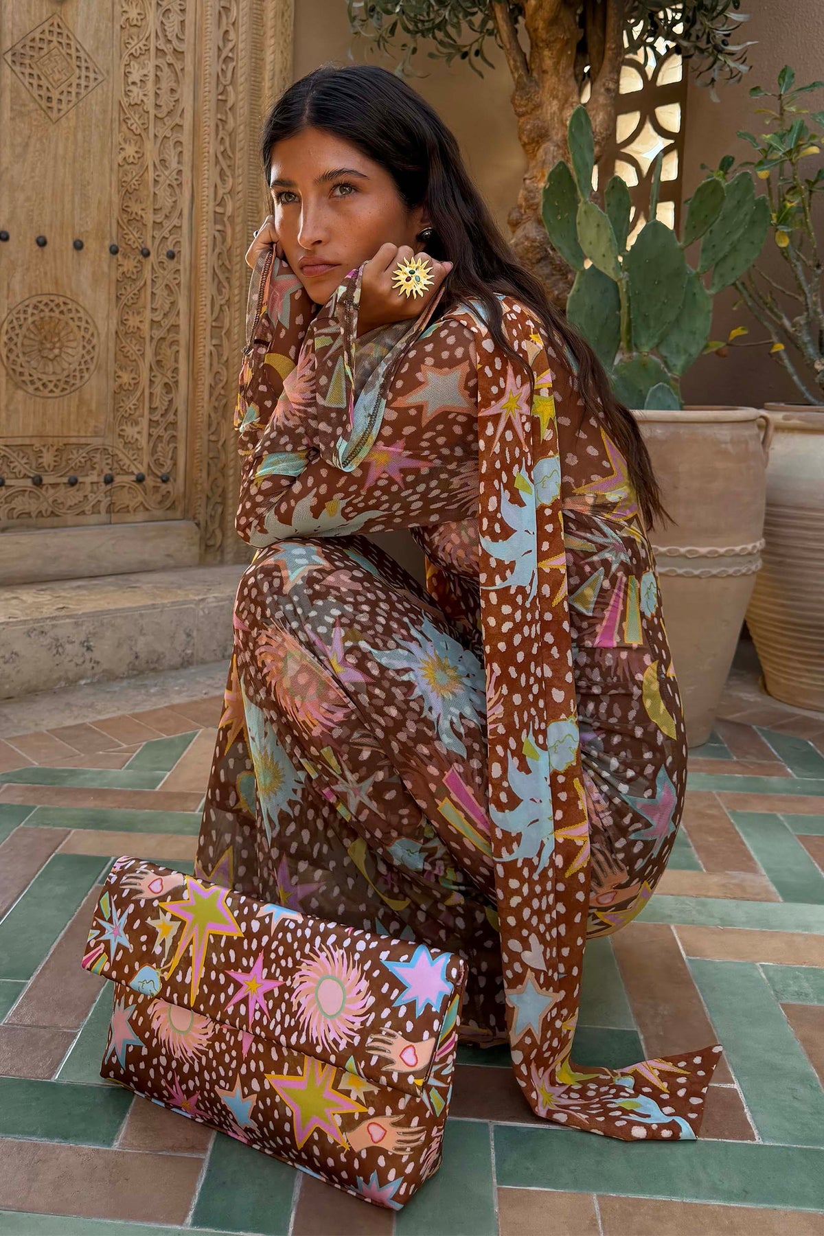 Brown Star Fawn Aria Mesh Dress featuring fawn spots and sun motifs, paired with a matching printed clutch bag.