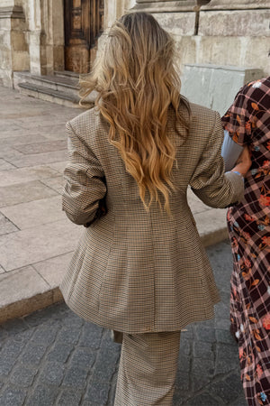 Blazer a quadri strutturato con orlo svasato sul retro, abbinato a pantaloni coordinati in città.